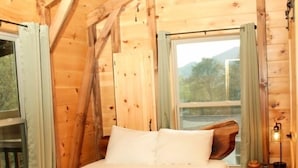 A wooden cabin bedroom with a bed, a ceiling fan, a window, and a nightstand. - Turkey Trot- New Cabin in Black Mountain w/ views & discount Biltmore tickets! (Black Mountain)