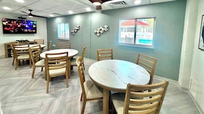 A conference room with round tables and chairs, a ceiling fan, and a television on the wall. - Lovers Key Beach Club Suite - Private Beach (Fort Myers Beach)