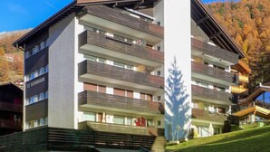 A multi-story hotel with balconies, a sign reading "St. Bernhard", and a mountain backdrop. - St. Bernhard by Interhome (Zermatt)