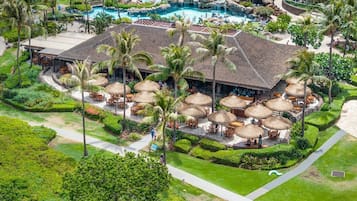 Een resort met een groot zwembad, buiten zitgedeeltes en weelderige begroeiing.