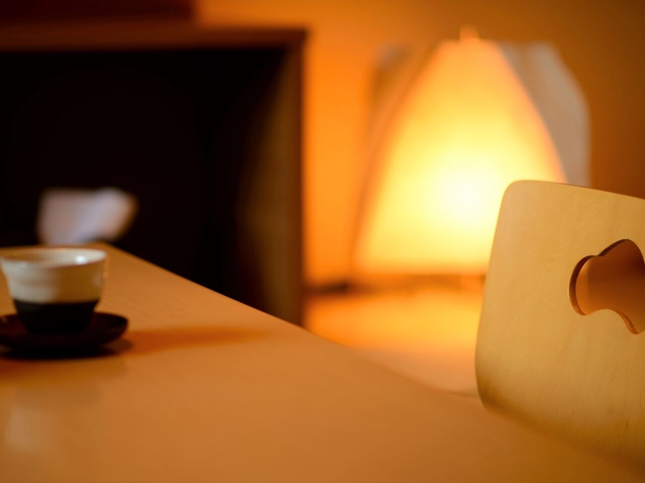 Ein Tisch mit einer Tasse und einer Lampe.
