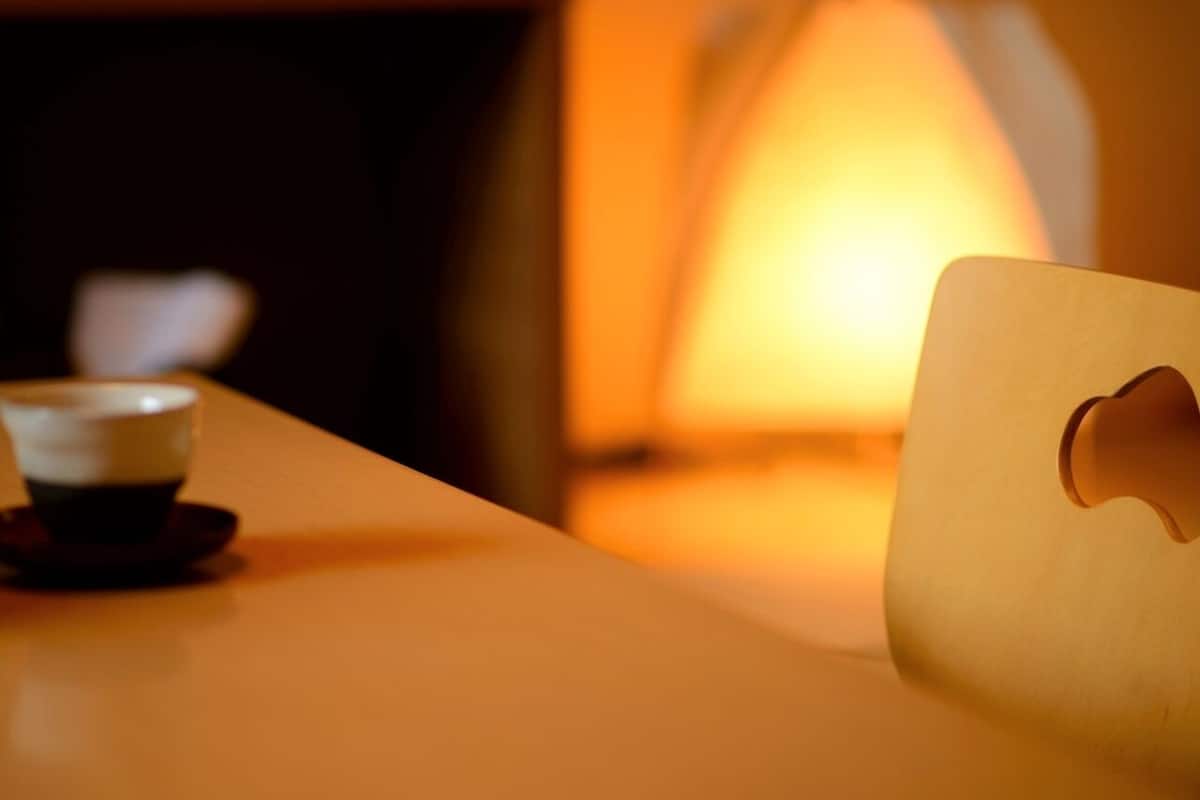 Een tafel met een kop en een lamp.