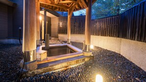 A hot tub under a wooden pergola with stone steps leading up to it, surrounded by a gravel area and a wooden fence. - Appi Kogen Mori no Hotel (Hachimantai)