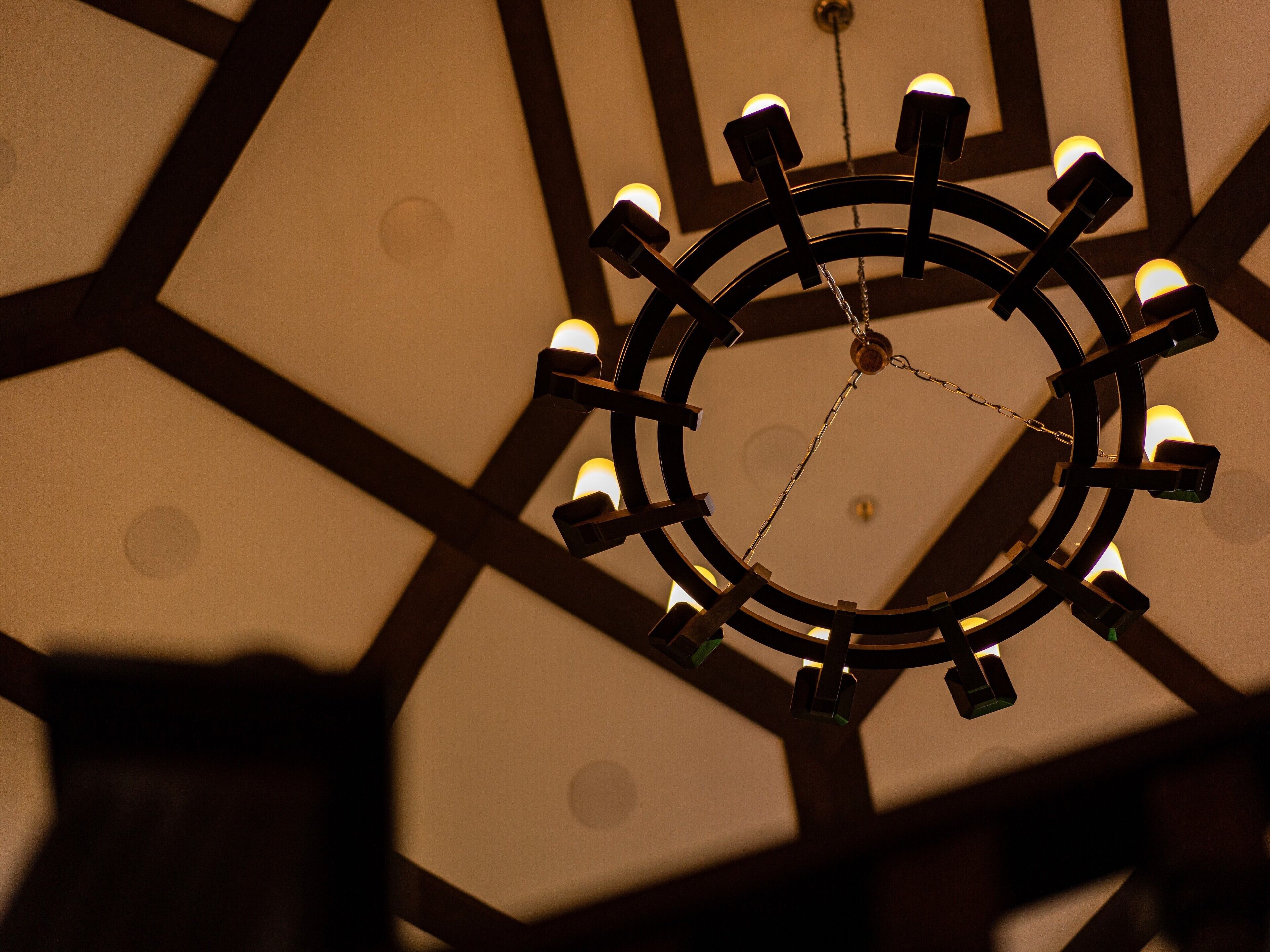 A geometric ceiling design with a central circular light fixture.