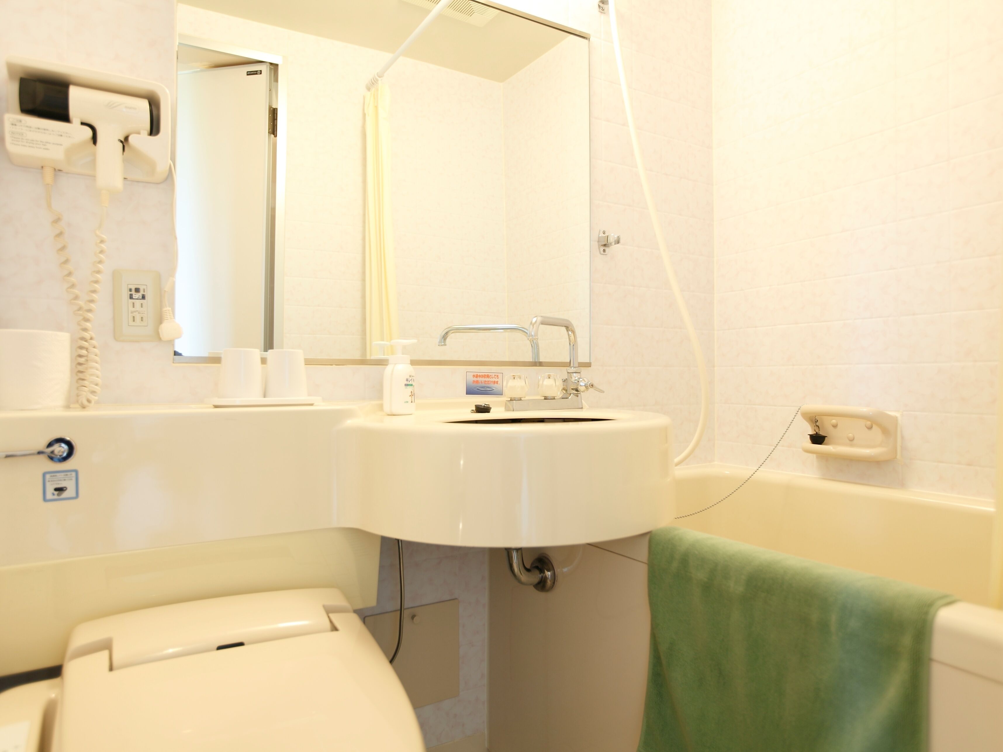 A bathroom with a sink, toilet, and a mirror.