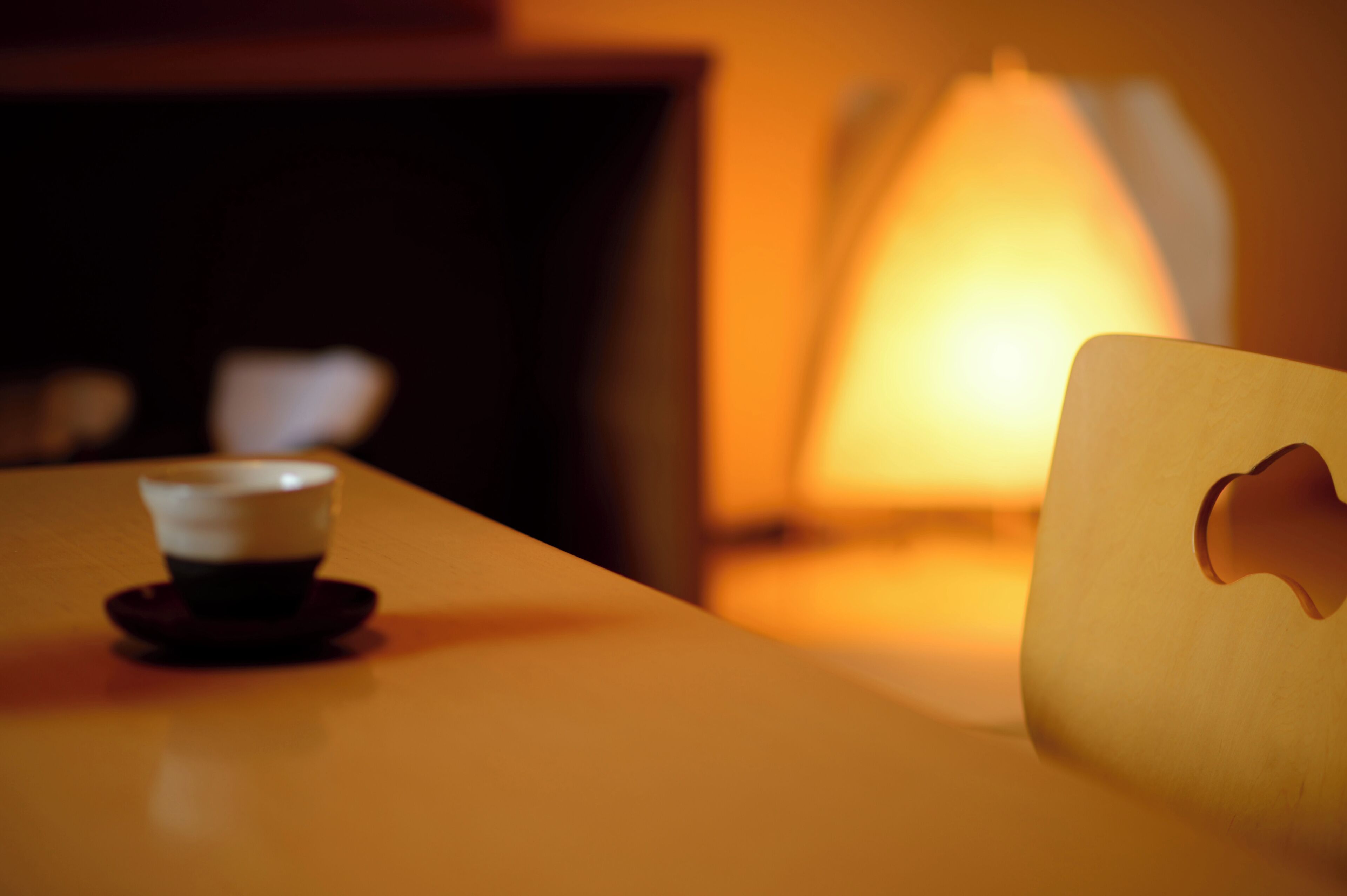 Un tavolo con una tazza di caffè e una lampada.