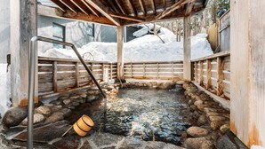 A wooden hot spring bath with a stone floor, surrounded by snow. - Appi Kogen Mori no Hotel (Hachimantai)