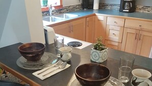 A kitchen with a central island, wooden cabinets, and a coffee maker.