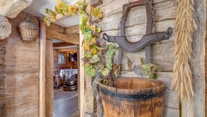 Un intérieur rustique en bois, agrémenté d’une grande barrique, d’un crochet métallique suspendu et d’un panier en osier.