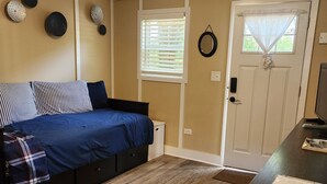 A bedroom with a bed, a desk, and a door. - ScrappyJax Cozy Cabin #4 (Glenwood)