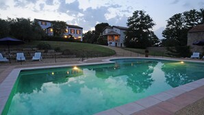 A swimming pool with lounge chairs and a landscaped area with houses in the background. - Le Hameau Montplaisir, its 4 houses, 36 beds and 2 large swimming pools! (Béziers)