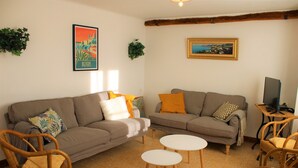 A living room with two sofas, a coffee table, and wicker chairs. - Le Hameau Montplaisir, its 4 houses, 36 beds and 2 large swimming pools! (Béziers)