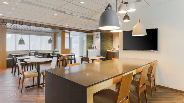 A modern dining area with a central island, multiple tables, and chairs.