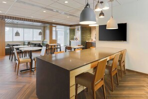 A modern dining area with a central island, multiple tables, and chairs. - Fairfield Inn & Suites by Marriott Cape Coral/North Fort Myers (Cape Coral)
