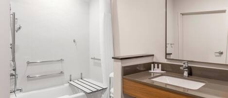 A modern bathroom with a bathtub, shower, and sink.