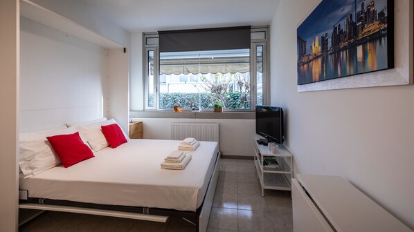 Espacio para trabajar con laptop y tabla de planchar con plancha 