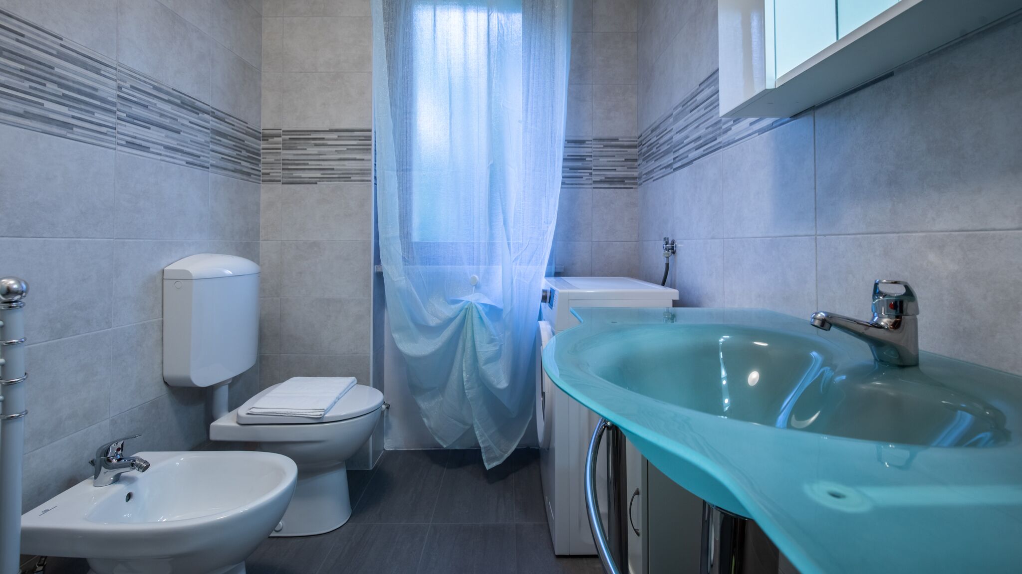 Ein modernes Badezimmer mit Toilette, Bidet und Waschbecken.