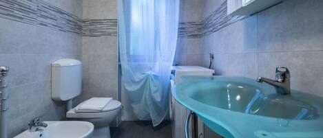 Ein modernes Badezimmer mit Toilette, Bidet und Waschbecken.