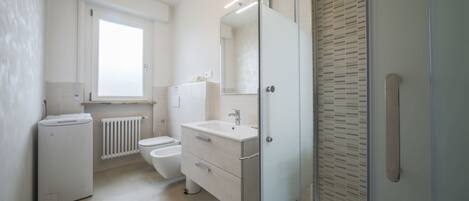 Un baño moderno con inodoro, lavamanos y ducha.