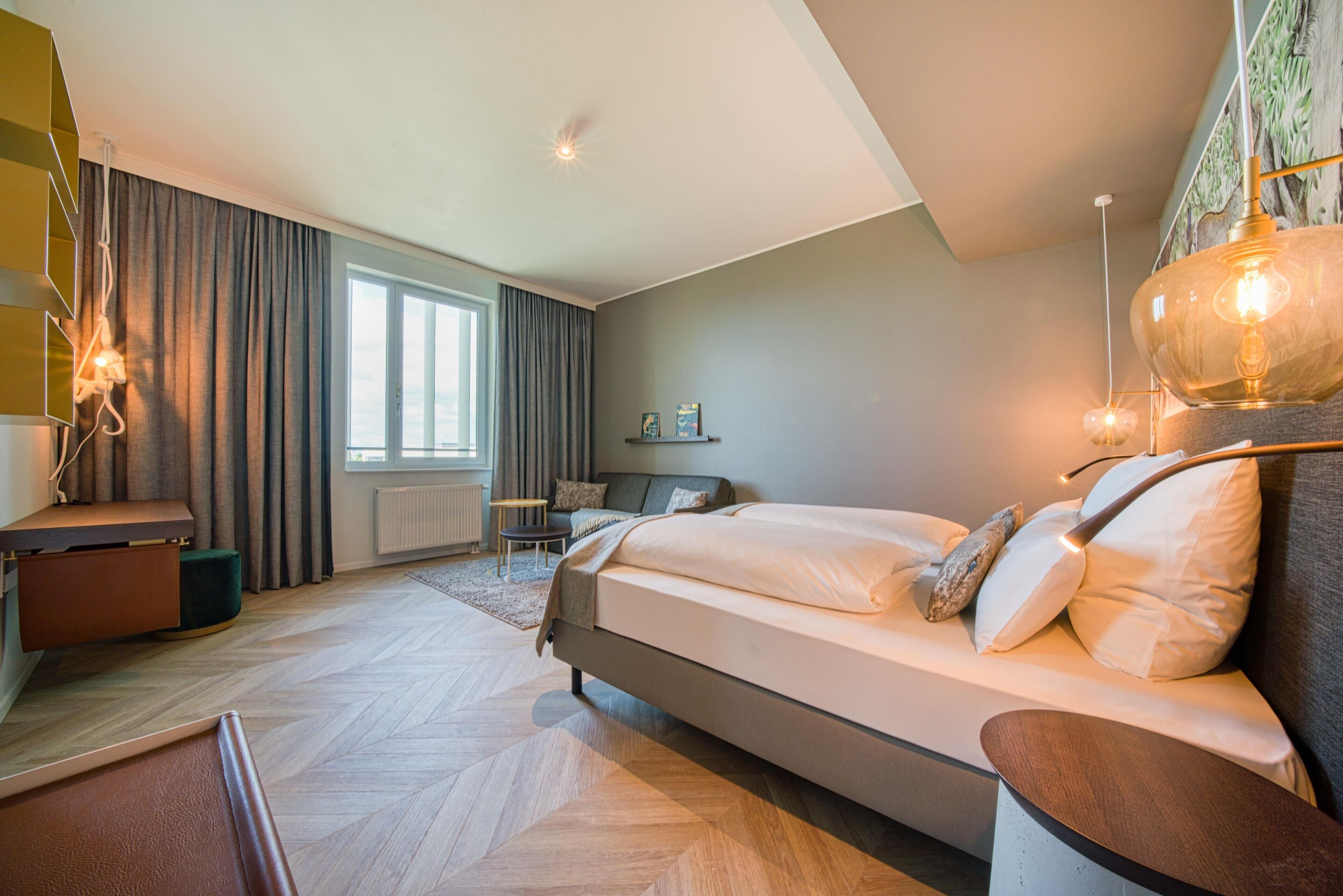 A modern bedroom with a large bed, a desk, and a chair.