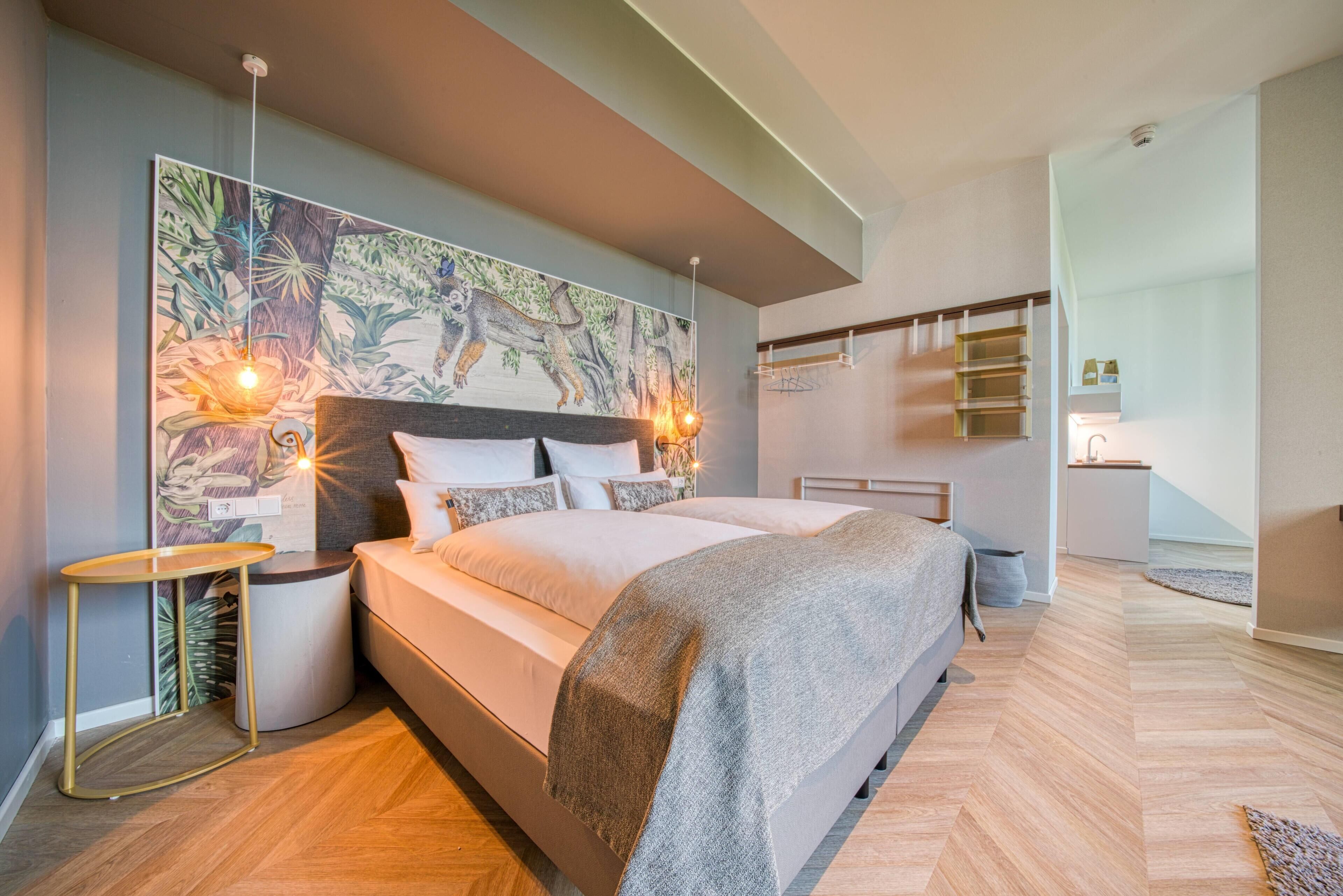 Un dormitorio moderno con una cama grande, una mesita de noche, un estante en la pared y un cuadro de gran tamaño.