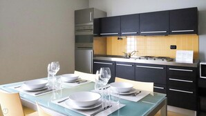 A modern kitchen with black cabinets, a stainless steel range, and a tiled backsplash. - Italianway - Dogali 17 (Santa Margherita Ligure)