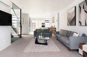 A modern living room with a sofa, coffee table, and artwork.