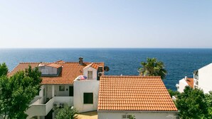 A coastal residential area with terracotta-tiled roofs, white buildings, and a view of the sea. - Apartment Bor (Dubrovnik)