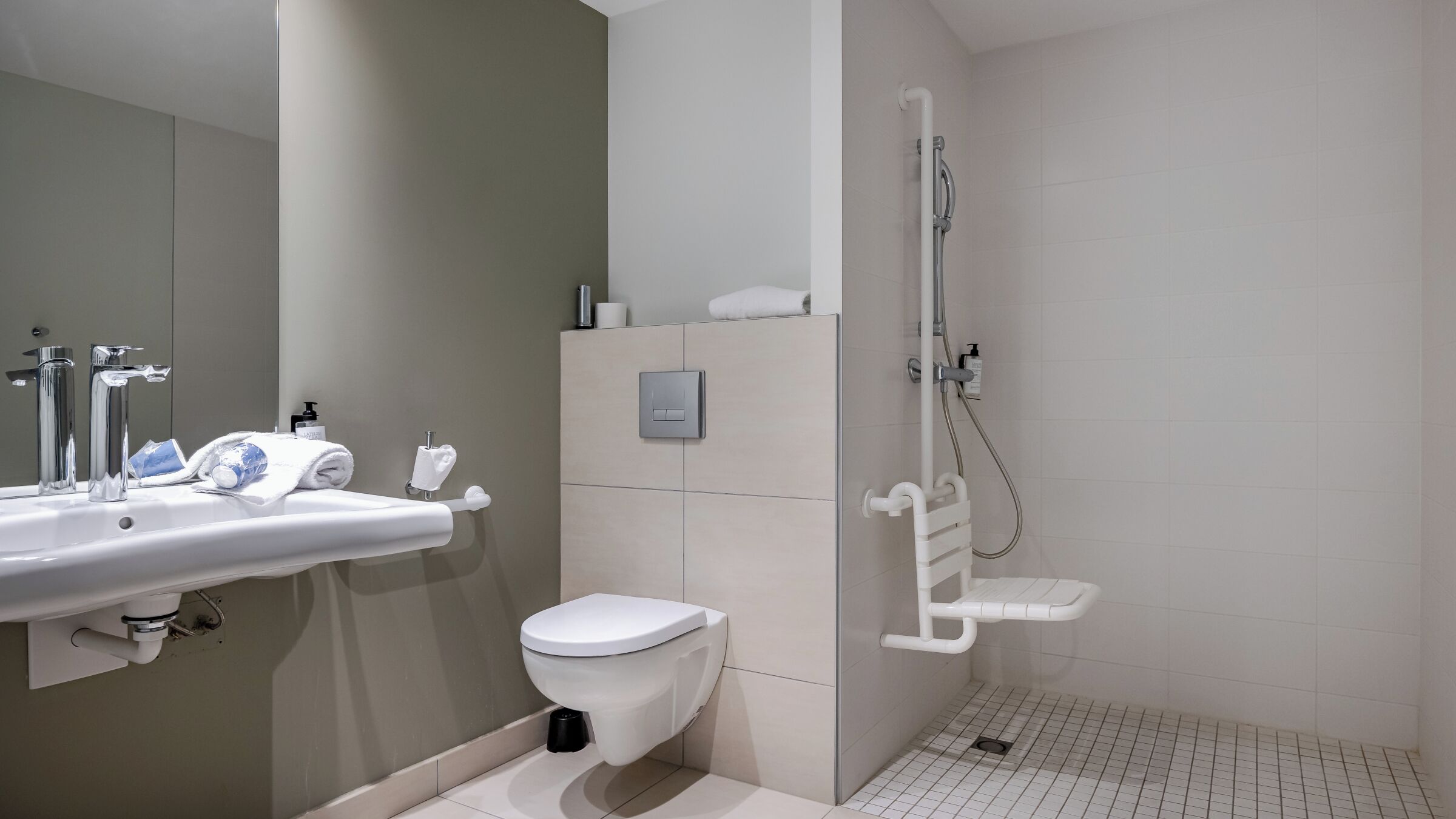 A modern bathroom with a sink, toilet, and shower.