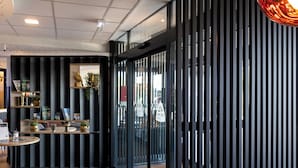 A modern interior with a wooden floor, glass doors, and a metal railing. - Hôtel AKENA TROYES - La Chapelle-Saint-Luc (La Chapelle-Saint-Luc)