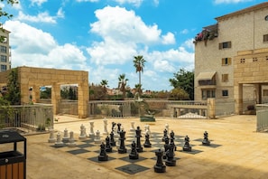 A chessboard set up outdoors with buildings in the background.