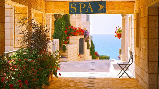 A spa entrance with a sign, a pathway, and a bench. - MAMAD - Deluxe 2BD Jaffa Dreams W Pool & Parking (Tel Aviv)