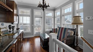 A spacious kitchen with wooden flooring, a marble countertop, and a chandelier. - Intensive Care ~ Steps From the Ocean w/ Golf Cart + Free Attraction Tickets! (Santa Rosa Beach)
