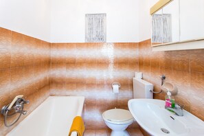 A bathroom with a bathtub, toilet, and sink.