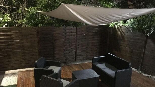 An outdoor patio with wicker furniture and a wooden deck. - Meduza Room (Montpellier)