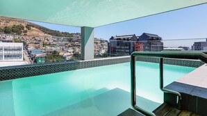 A rooftop pool with a clear view of a cityscape and a hilly area in the background. - Backup-Power Lavish Eclectic City View Apartment on Popular Bree Street (Cape Town)