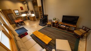Un vaste espace de vie comprenant un canapé, une table basse, un téléviseur et une cheminée.