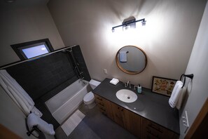A modern bathroom with a bathtub, toilet, and sink.