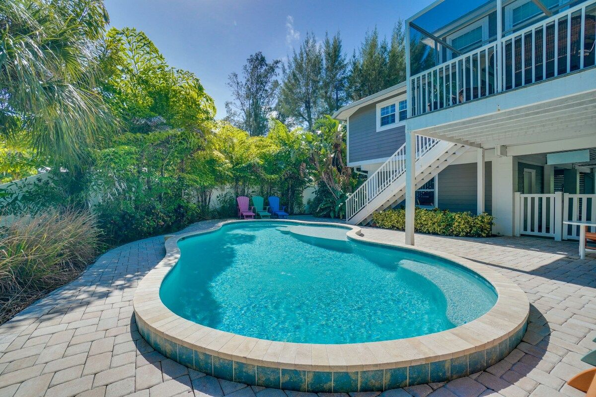 A swimming pool with a curved edge, surrounded by a brick patio.