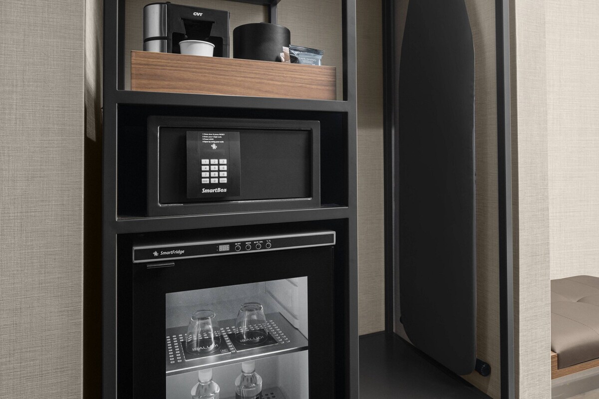 A kitchen area with a built-in microwave, a coffee maker, and a coffee machine on the countertop.