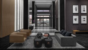 A modern lobby with a checkered floor, a reception desk, and seating areas. - AC Hotel by Marriott Columbus Downtown (Columbus)