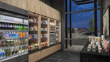 A well-lit grocery store with shelves stocked with beverages, snacks, and packaged goods.