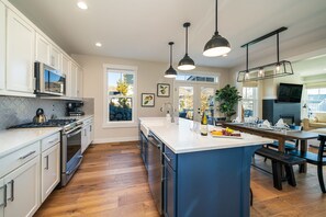 Enjoy cooking in this well-equipped kitchen with a central island, stove, and oven.