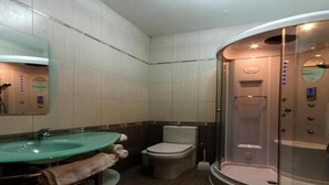 A modern bathroom with a glass-enclosed shower, a sink with a mirror, and a toilet. - Misrah Simar (Qala)