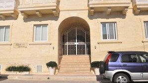 A beige building with a gated entrance, a sign reading "Moorish Square," and a parked car in front. - Misrah Simar (Qala)
