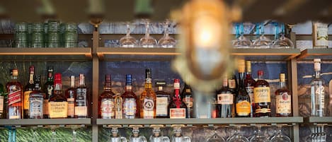 Un bar con estantes llenos de botellas de licores y vasos.