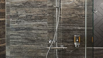Eine moderne Dusche mit Regendusche und Handbrause, einer Glasabtrennung und einer Bedienkonsole.