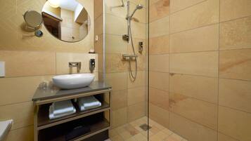Een moderne badkamer met een grote spiegel, een wastafel en een douche.