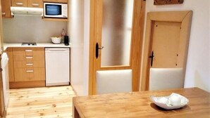 A compact kitchen with wooden cabinets, a microwave, and a dishwasher.
