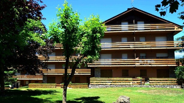 A multi-story building with a flat roof and horizontal wooden slats on the facade.